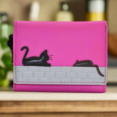 A pink Mala Leather tri-fold purse with a cat and mouse design when closed.