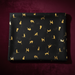 Black fabric with gold cat pattern on a dark red background