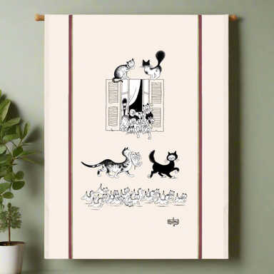 Tea towel with black and white cat illustrations on a beige background