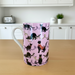 Mug with black cat pattern on a pink background in a kitchen setting