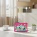 Pink pouch with colorful design on a table with a cup and glasses