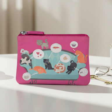 Pink pouch with colorful design on a table with a cup and glasses