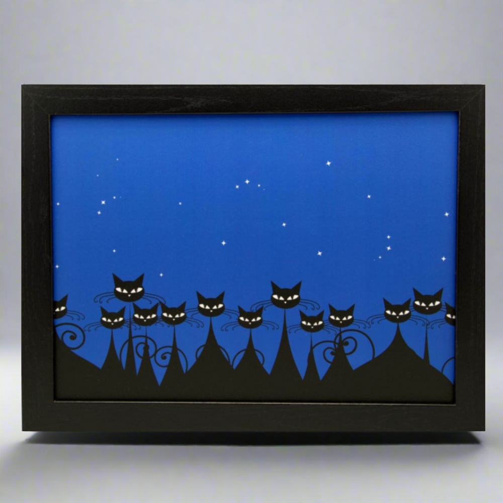 Framed artwork of black cats on a blue background with a black frame.