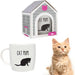 A ceramic mug with a black cat and paw print pattern, accompanied by a cat house-shaped gift box, and a real cat sitting beside it.