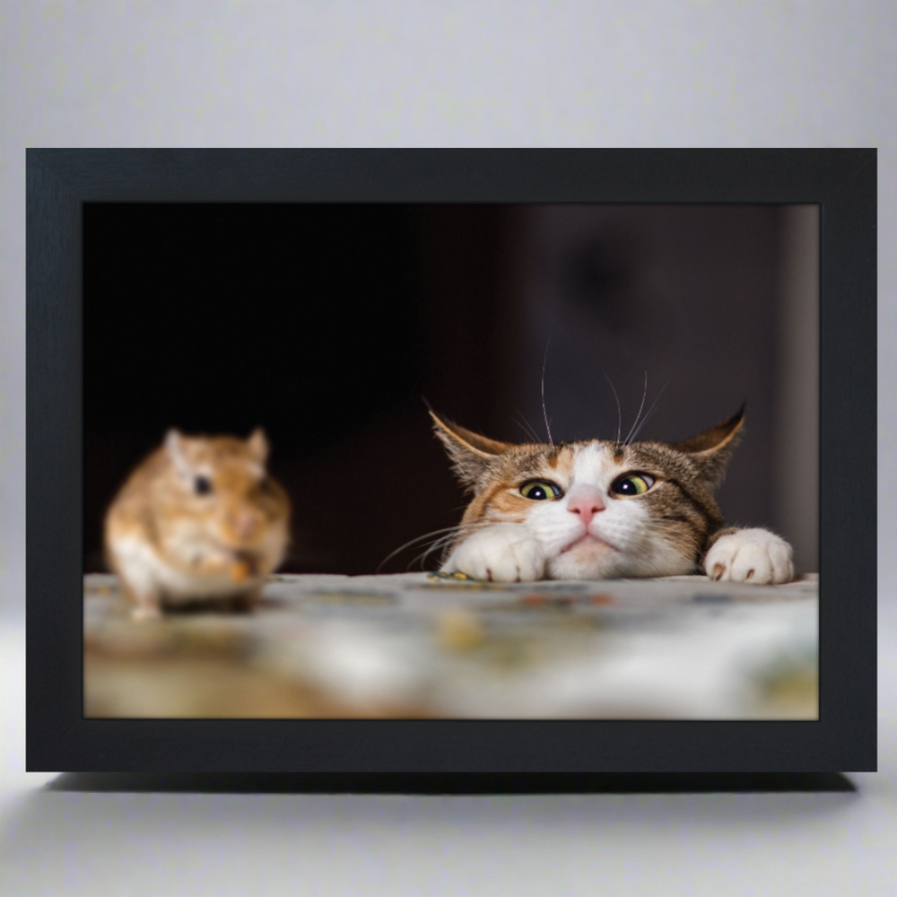 A black frame lap tray featuring an image of a cat peeking over the edge with a mouse in sight.