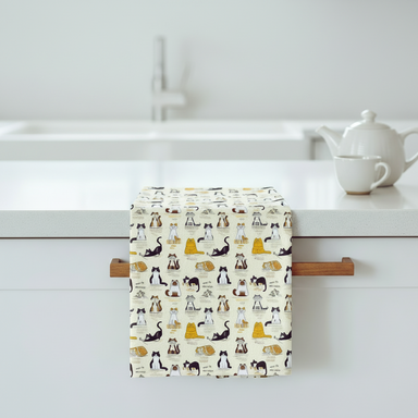 Towel with cat pattern hanging on a rack against a white background