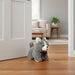 Plush cat toy on a wooden floor with a living room in the background