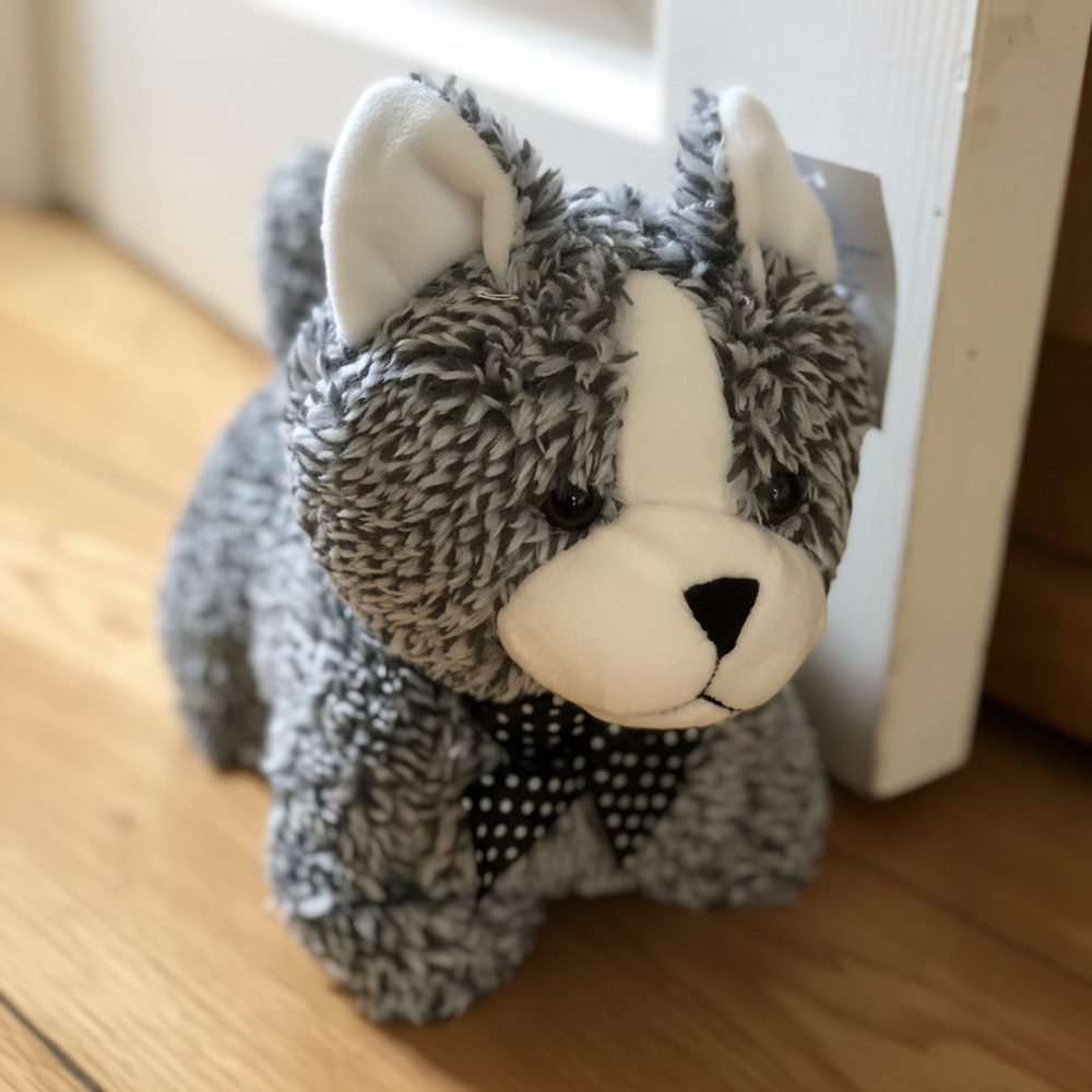 Plush toy cat with a bow tie on a wooden floor