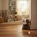 Plush toy cat on a wooden floor in a cozy living room.